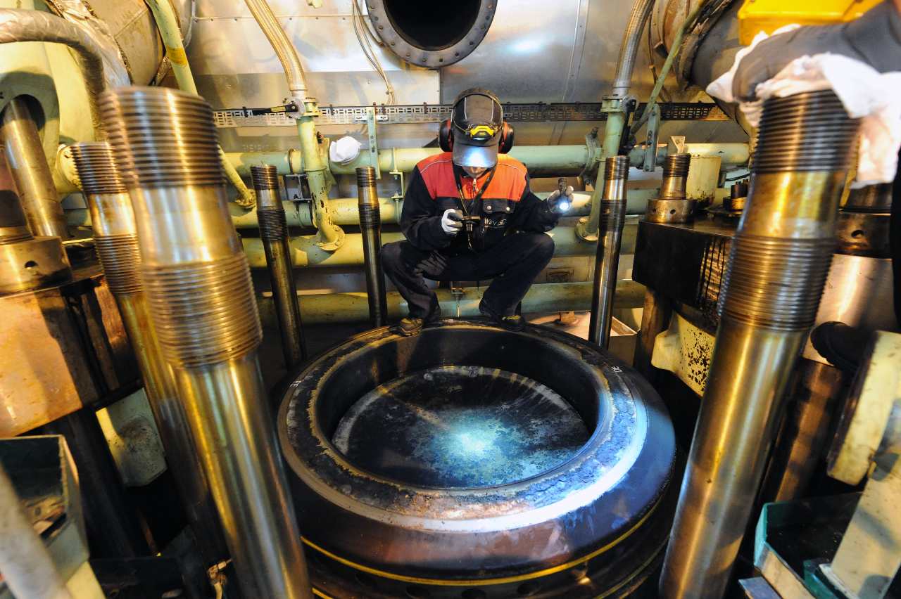 Marine Lubricant Engineer Inspecting a 2-Stroke Engine Cylinder from above