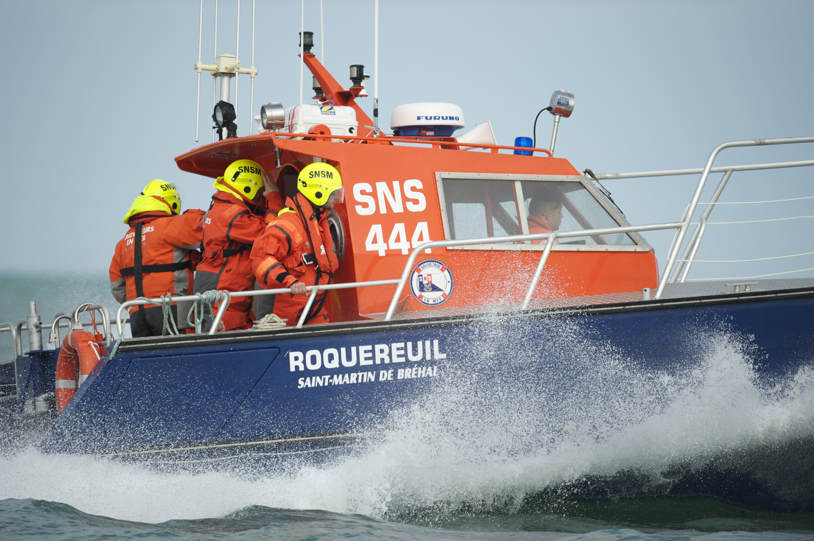 An SNSM rescue boat is operating at sea with its rescue team on the deck