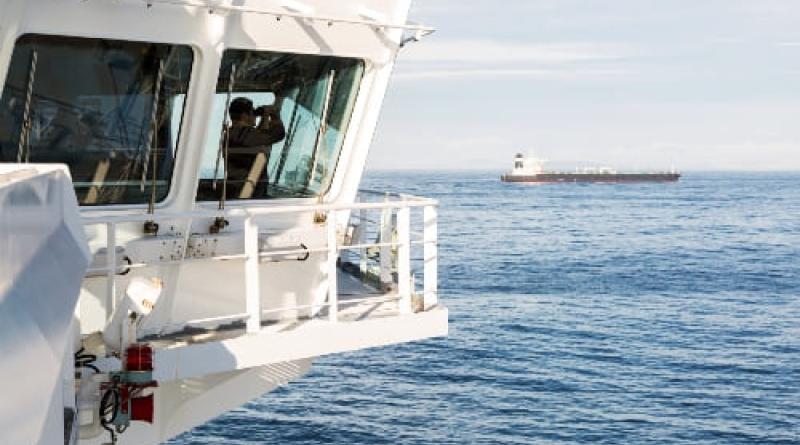 Man on a boat using binoculars