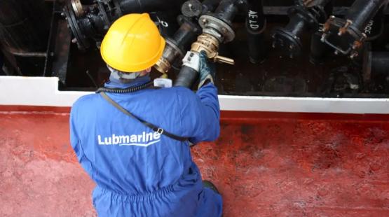Barge operator in PPE holding a hose after a marine lubricants delivery.