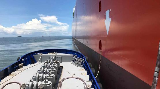 Barge delivering lubricant alongside a cargo vessel