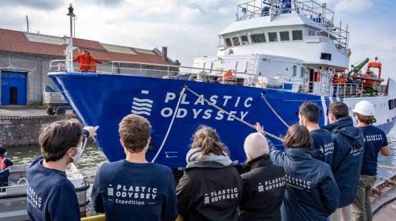 Plastic Odyssey boat launching in Dunkerque, some association members are standing on the dock, looking at the Plastic Odyssey ship.