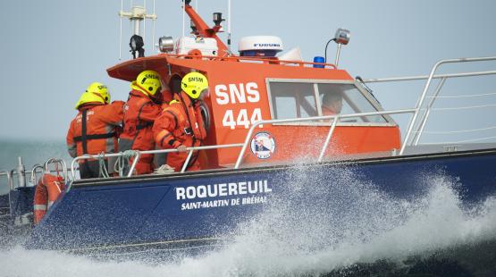 An SNSM rescue boat is operating at sea with its rescue team on the deck