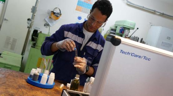 A technician wearing PPE during an onboard lubricant analysis operation